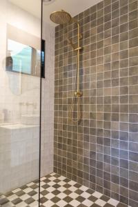 a shower with a glass door in a bathroom at Hot Water Hideaway in Hotwater Beach
