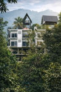 a tall white building with a palm tree on top of it at Skyscenic Munnar in Munnar