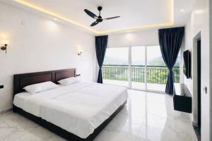a bedroom with a bed with a ceiling fan at Skyscenic Munnar in Munnar