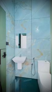 a bathroom with a sink and a toilet and a mirror at Skyscenic Munnar in Munnar
