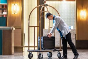 a man pushing a luggage cart in an airport at Guilin Yangshuo Shixi Landscape Hotel in Yangshuo +104 photos