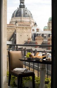 a dining room table with a balcony overlooking a city at Grand Hotel Saint Michel in Paris