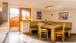a kitchen with a wooden table and chairs at Appartement Stuibenfallblick in Umhausen