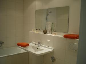 a bathroom with a sink and a mirror and a tub at Ferienwohnung Nr.31 in Warnemünde