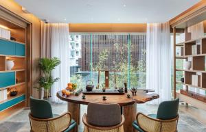 a dining room with a table and chairs and a large window at Guilin Yangshuo Shixi Landscape Hotel in Yangshuo