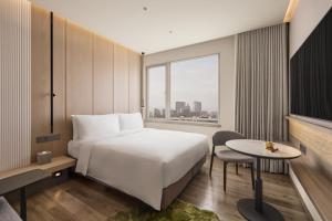 ein Hotelzimmer mit einem Bett, einem Tisch und einem Fenster in der Unterkunft Hotel UKETAMO in Taipeh