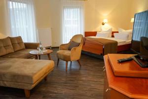 a hotel room with two beds and a couch at Hotel Lorösch in Bad Orb