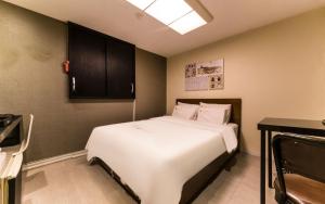 a bedroom with a large white bed in a room at Donkey Hotel in Bucheon