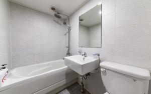 a bathroom with a sink and a toilet and a tub at Donkey Hotel in Bucheon