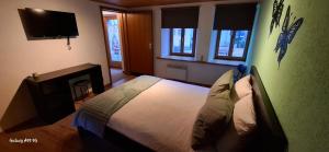 a bedroom with a bed and a tv and windows at B&B Lostallo Beat and Bloom in Lostallo