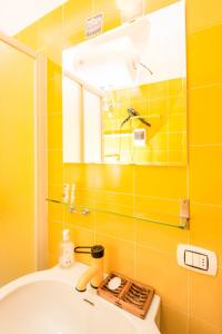 a yellow bathroom with a sink and a mirror at Terrace with a view! in Moltrasio +14 photos