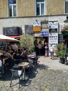 a group of people sitting at tables outside a restaurant at All you need is Love1 in Bratislava
