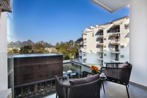 a balcony with chairs and a view of a building at Guilin Yangshuo Shixi Landscape Hotel in Yangshuo