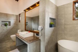 a bathroom with a sink and a toilet and a mirror at Arinna Beach Resort in Tangalle +33 photos