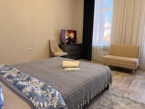 a bedroom with a bed and a tv and a chair at Old Town Hostel Gyumri in Gyumri