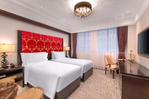 a hotel room with two beds and a television at TUI BLUE Yangtze Shanghai in Shanghai