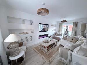 a white living room with a couch and a table at Southkey House in Repton