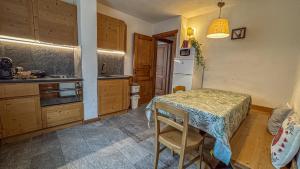 a kitchen with a table and a small kitchen with a table and chairs at Appartamento Montagnards in Morgex +4 photos