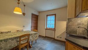 a kitchen with a table and a sink and a window at Appartamento Montagnards in Morgex