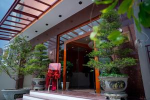 a entrance to a building with potted trees in pots at Khách sạn Mona in Dĩ An