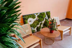 a living room with two chairs and a christmas tree at Khách sạn Mona in Dĩ An
