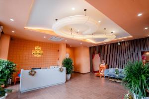 a lobby with orange walls and a large ceiling at Khách sạn Mona in Dĩ An
