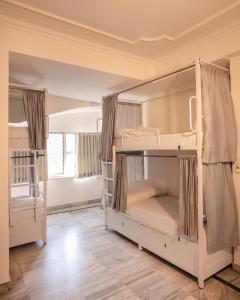 two bunk beds in a room with wooden floors at Hammock Hostels - Jaipur in Jaipur