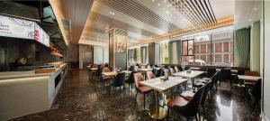 a restaurant with tables and chairs in a room at Nanyang King's Gate Hotel in Guangzhou