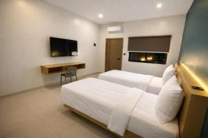 a hotel room with two beds and a desk at Bene Residence in Maluk