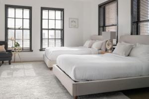 two beds in a white room with windows at Gorgeous Apartment 2-bedroom 2-bathroom in Los Angeles