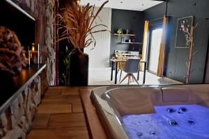 a bath tub with blue water in a room at Lunic1926 in Manhay