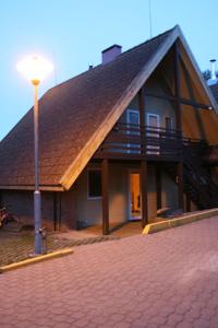 a house with a large roof with a light pole at Vila Goda & Vila Roma in Neringa