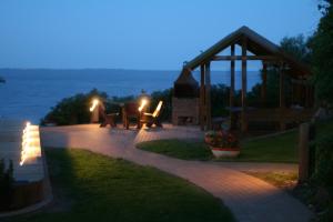 a patio with a table and a gazebo at night at Apartamentai Roma in Neringa