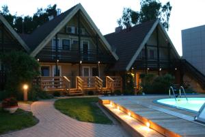 a house with a swimming pool in front of a house at Apartamentai Roma in Neringa
