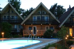 a house with a pool in front of it at Apartamentai Roma in Neringa