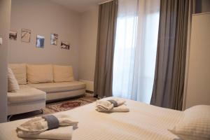 a hotel room with two beds and a couch at Къща за гости В 12 и 5 in Dolna Banya