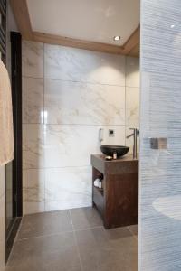 a bathroom with a sink and a glass wall at MGM Hôtels & Résidences - Résidence Manaka in Aime-La Plagne