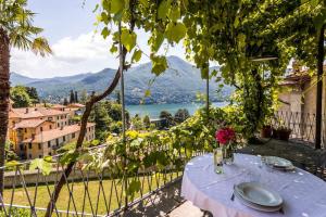 a table on a balcony with a view of a lake at Terrace with a view! in Moltrasio