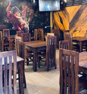 a restaurant with wooden tables and chairs and a painting on the wall at New National in Pettah