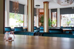 a dining room with blue chairs and a table at Hotel Lorösch in Bad Orb