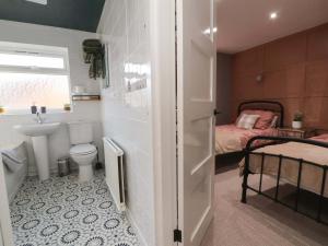a bathroom with a toilet and a sink and a bed at Steam and Stay Hoole in Chester +28 photos
