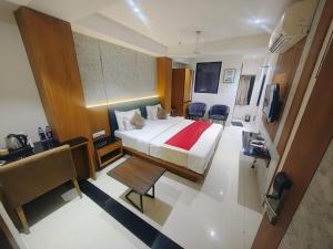 a hotel room with a bed and a desk at Hotel Ranjeet Akola in Akola