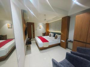 a hotel room with a bed and a chair at Hotel Ranjeet Akola in Akola +96 photos