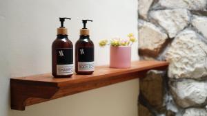 two bottles of wine sitting on a wooden shelf at Among Villa in Yogyakarta