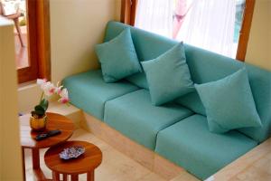 a blue couch with pillows in a living room at Among Villa in Yogyakarta