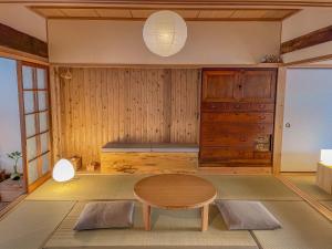 ein Wohnzimmer mit einem Tisch und einem Schrank in der Unterkunft ichi Mimitsu in Hyuga