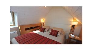 a bedroom with a large bed with two pillows at Le Churchill Hôtel & Spa in Carnac