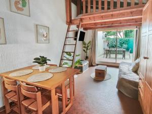 a living room with a table and a loft bed at Studio Cosy avec terrasse et parking privé in Cap d'Agde