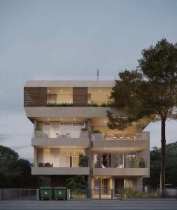 a large apartment building with balconies and a tree at Pinewood by Holistays in İncirli
