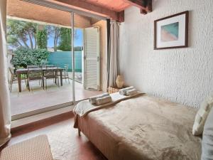 a bedroom with a bed and a balcony with a table at Studio Cosy avec terrasse et parking privé in Cap d'Agde